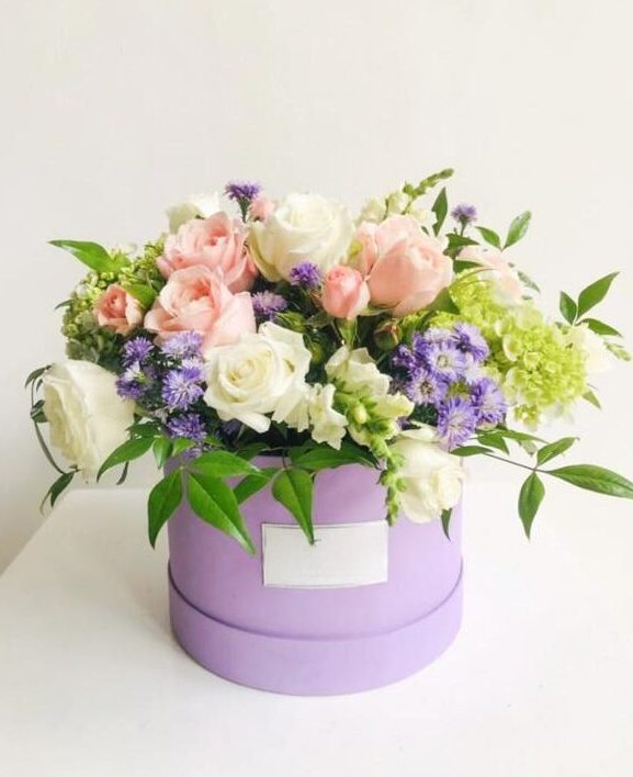 An assortment of Pink Roses, White Roses & Green Hydrangeas in a Purple Round Box