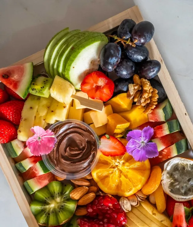 Indulge in the vibrant freshness of our small fruit platter, perfect for serving 5 or more guests. Measuring 16 inches by 7 inches, this irresistible display features an array of juicy fruits complemented by a luscious chocolate dip, and your choice of chicken or beef mortadella cheese, nuts, and delightful fruit skewers. Elevate your table's aesthetics and culinary experience with this exquisite choice.