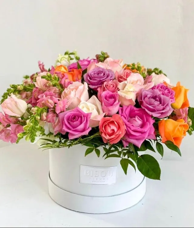 Gift your loved one, shades of pink and orange roses in a round white box