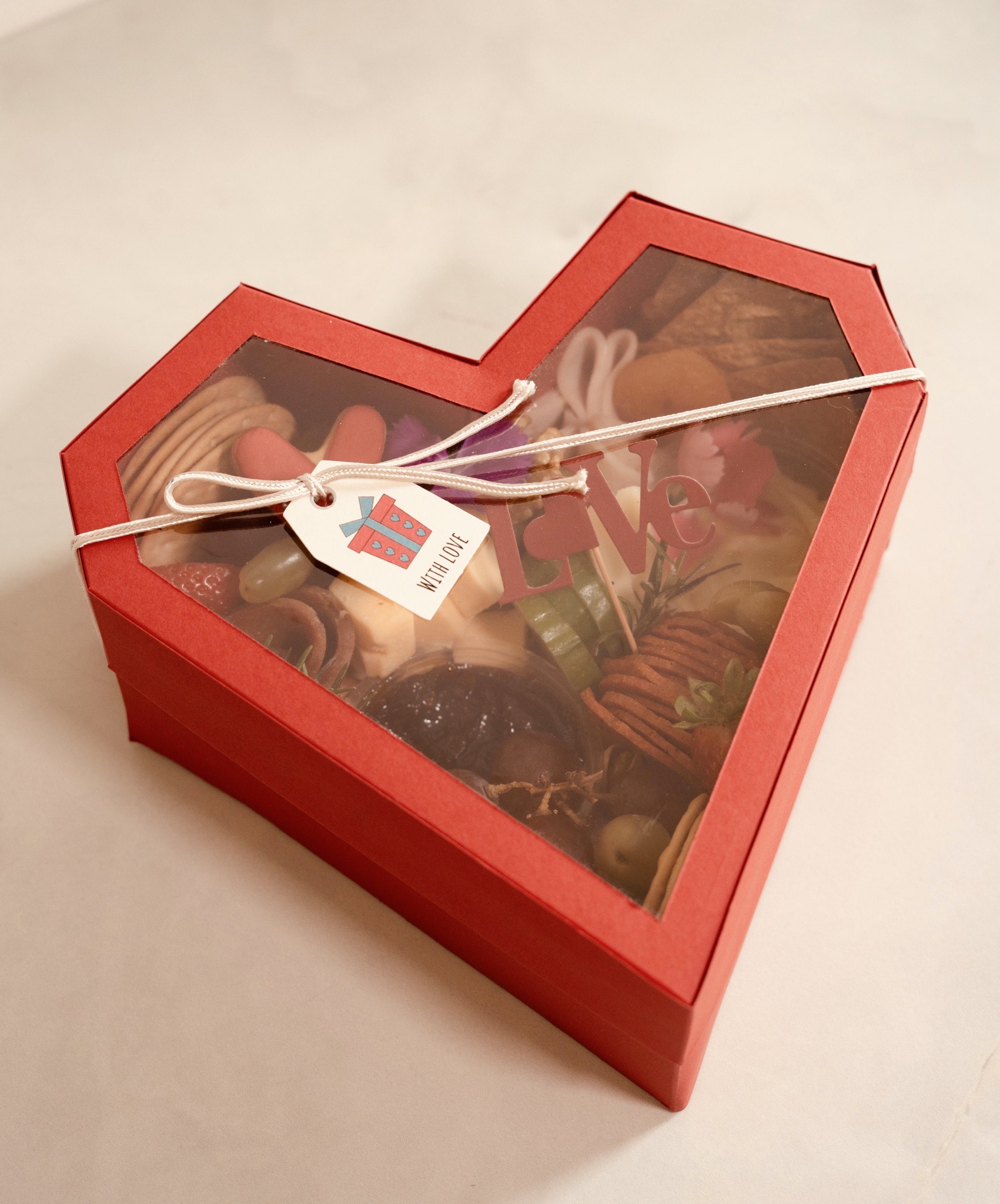 Heart-shaped platter box: small-sized and includes Chicken or beef mortadella, cold cuts, fruits, crackers, and accoutrements. Comes with dips such as Date and Lime Chutney and Garlic and Herb Cheese. Perfect for serving 2 or more guests.