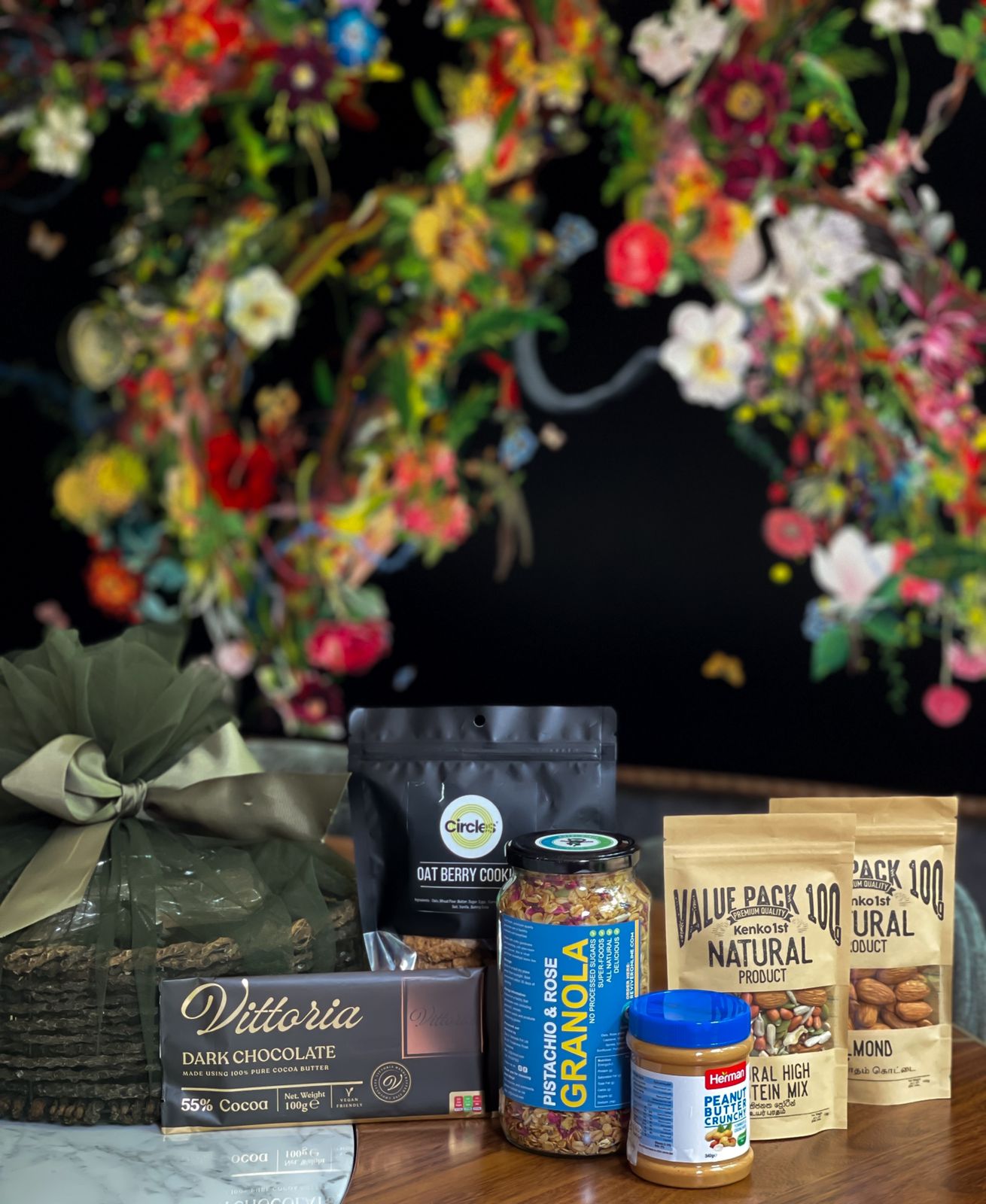 Delight your loved ones with a thoughtfully curated hamper filled with delicious and healthy treats. Item Includes: Natural high protein mix Almond Dark choc chips Granola Herman peanut butter crunchy Oat berry cookies Vittoria dark chocolate