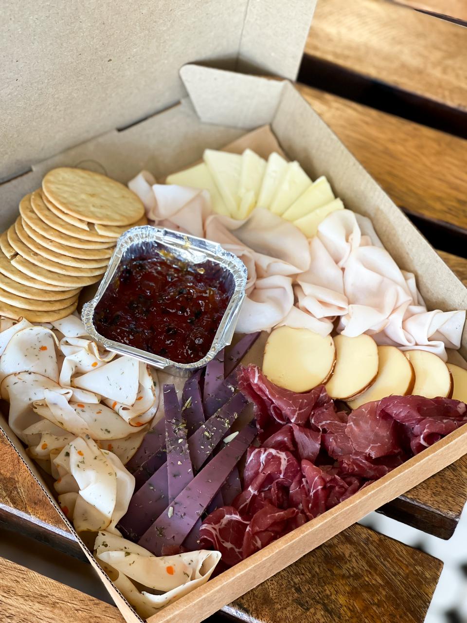 Delight your loved ones with a thoughtfully curated gourmet cheese and cold cuts platter, elegantly packaged in a cardboard box adorned with a ribbon and gift tag. Featuring premium selections like turkey ham, herb-seasoned chicken ham, and beef bresaola, paired with an exquisite assortment of smoked cheese, gouda with lavender, and edam, and jam this indulgent platter is perfect for any special occasion.