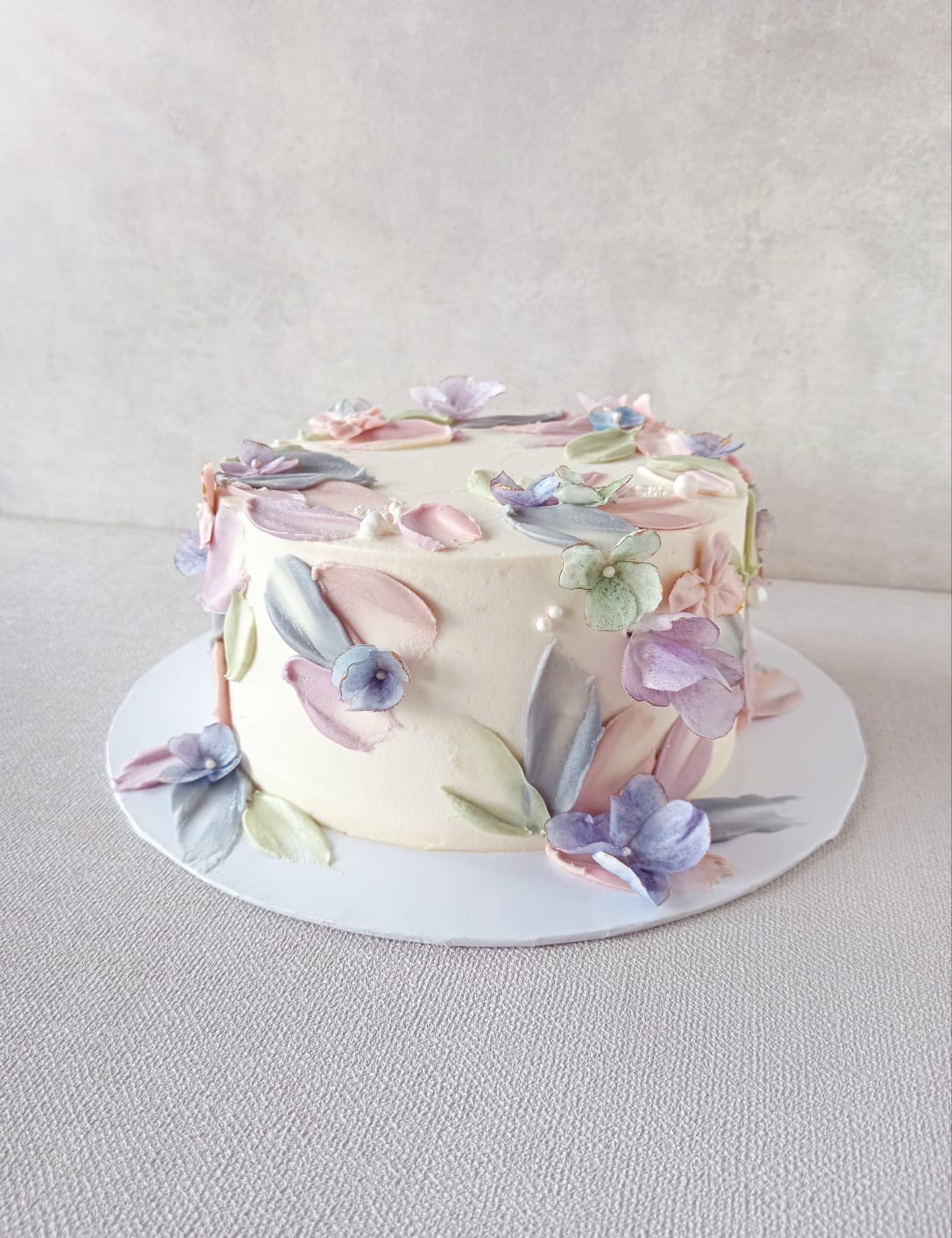 A cake with soft color Petals. Please note the flavor profile of your choice at checkout: Classic Vanilla or Dark Chocolate. The cake has dimensions of 6 inches in diameter and 3-4 inches in height