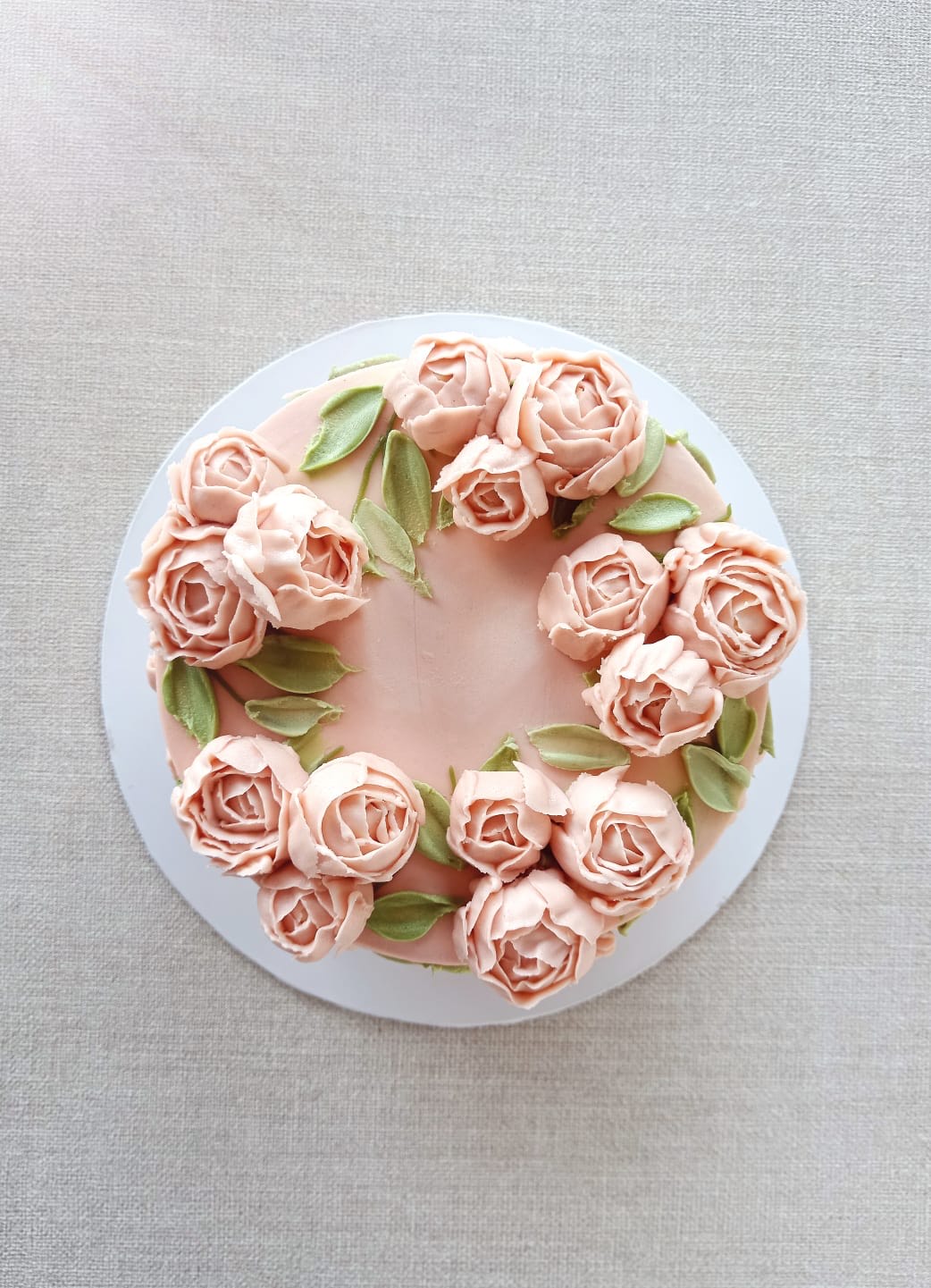 A cake with pink color roses on top. Please note the flavor profile of your choice at checkout: Classic Vanilla or Dark Chocolate. The cake has dimensions of 6 inches in diameter and 3-4 inches in height