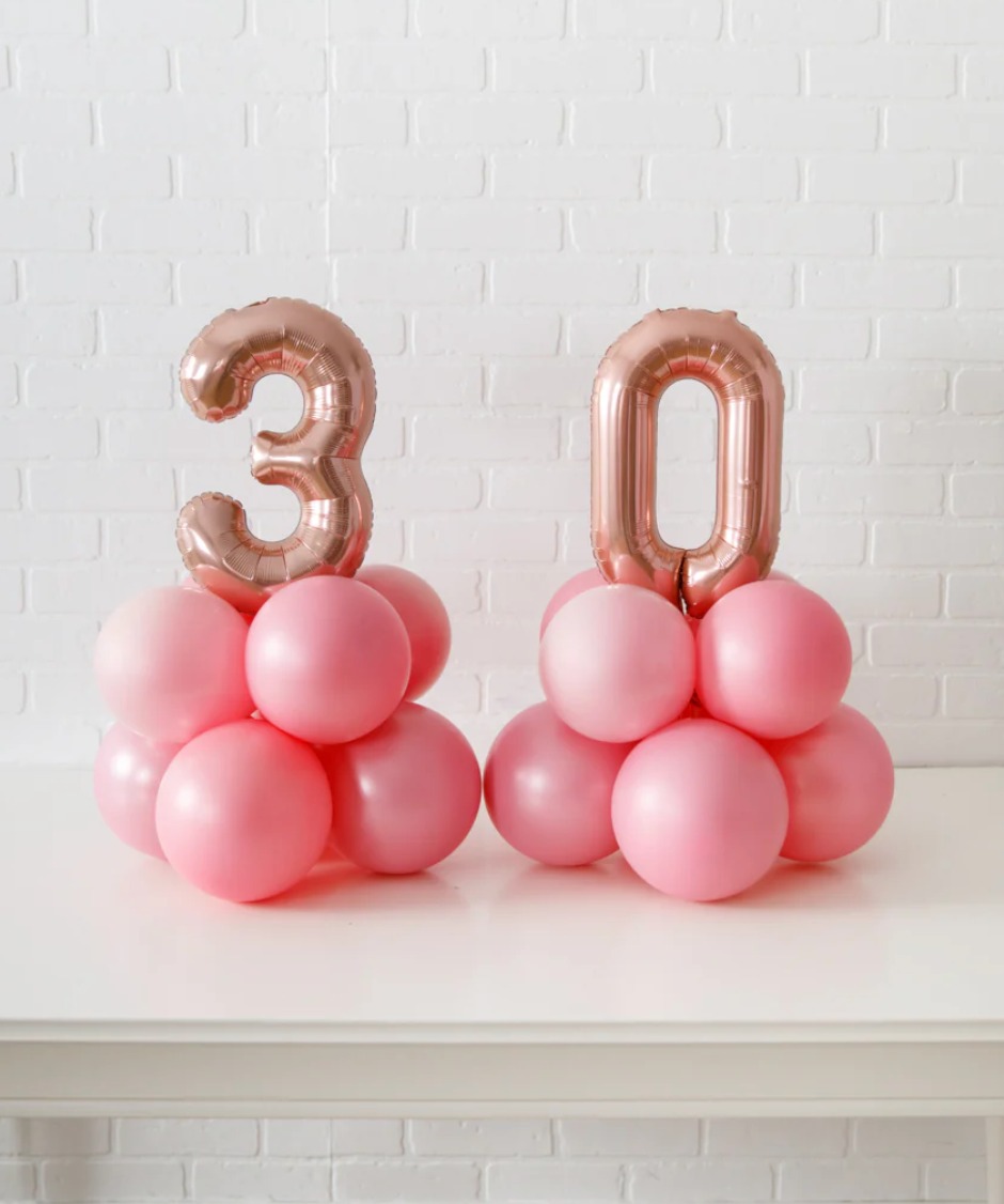 This arrangement features two number balloons (not helium) and latex balloons. The balloon color theme and numbers can be customized to your preference. Foil numbers are available in Gold, Silver, and Rose Gold, and they are 16” in size.