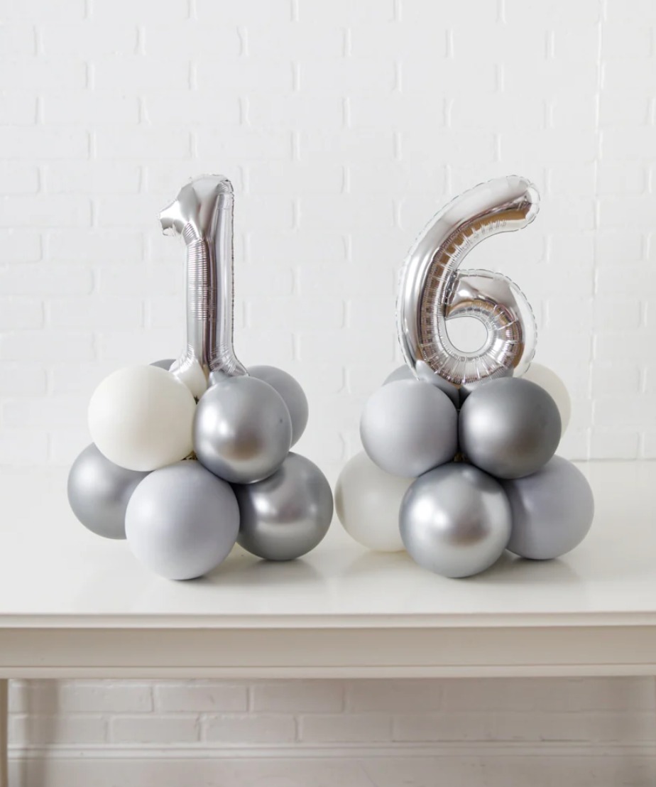 This arrangement features two number balloons (not helium) and latex balloons. The balloon color theme and numbers can be customized to your preference. Foil numbers are available in Gold, Silver, and Rose Gold, and they are 16” in size.
