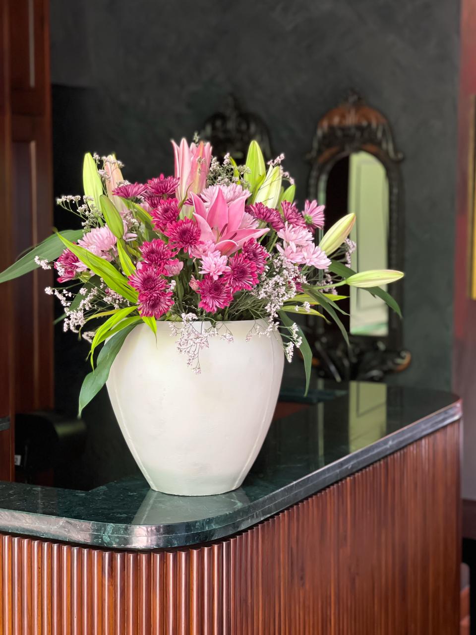 Surprise your loved one with an exquisite flower arrangement featuring delicate pink lilies and soft shades of pink chrysanthemums, all beautifully displayed in a stylish beige pot. A graceful gift that exudes elegance and warmth