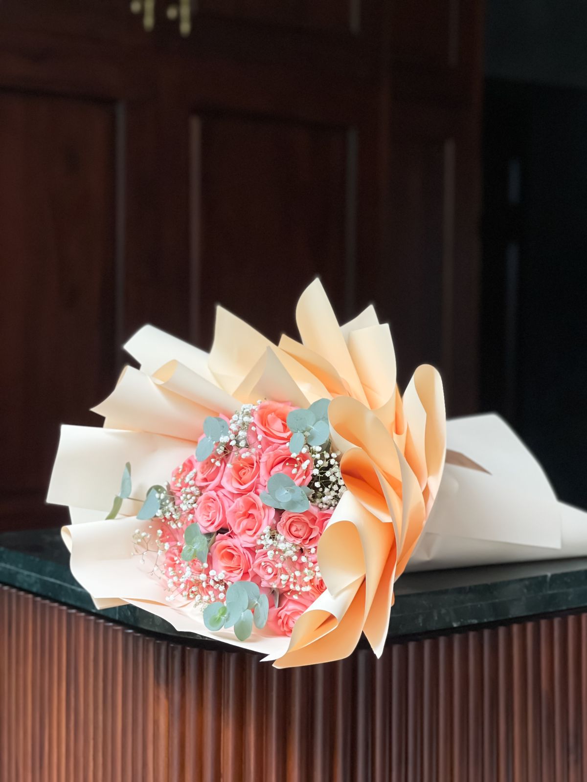 Surprise your loved ones with a breathtaking bouquet of 20 coral pink roses, elegantly wrapped in soft peach. A timeless expression of love and affection, this exquisite arrangement is crafted to brighten their day and leave a lasting impression