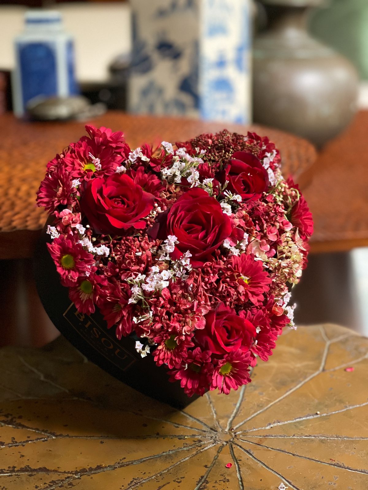 Give your loved one a beautiful heart-shaped arrangement featuring stunning red roses and vibrant red chrysanthemums