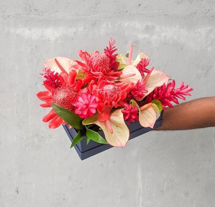 A stunning tropical arrangement in a sleek black box, featuring vibrant tropical flowers and exotic anthuriums.