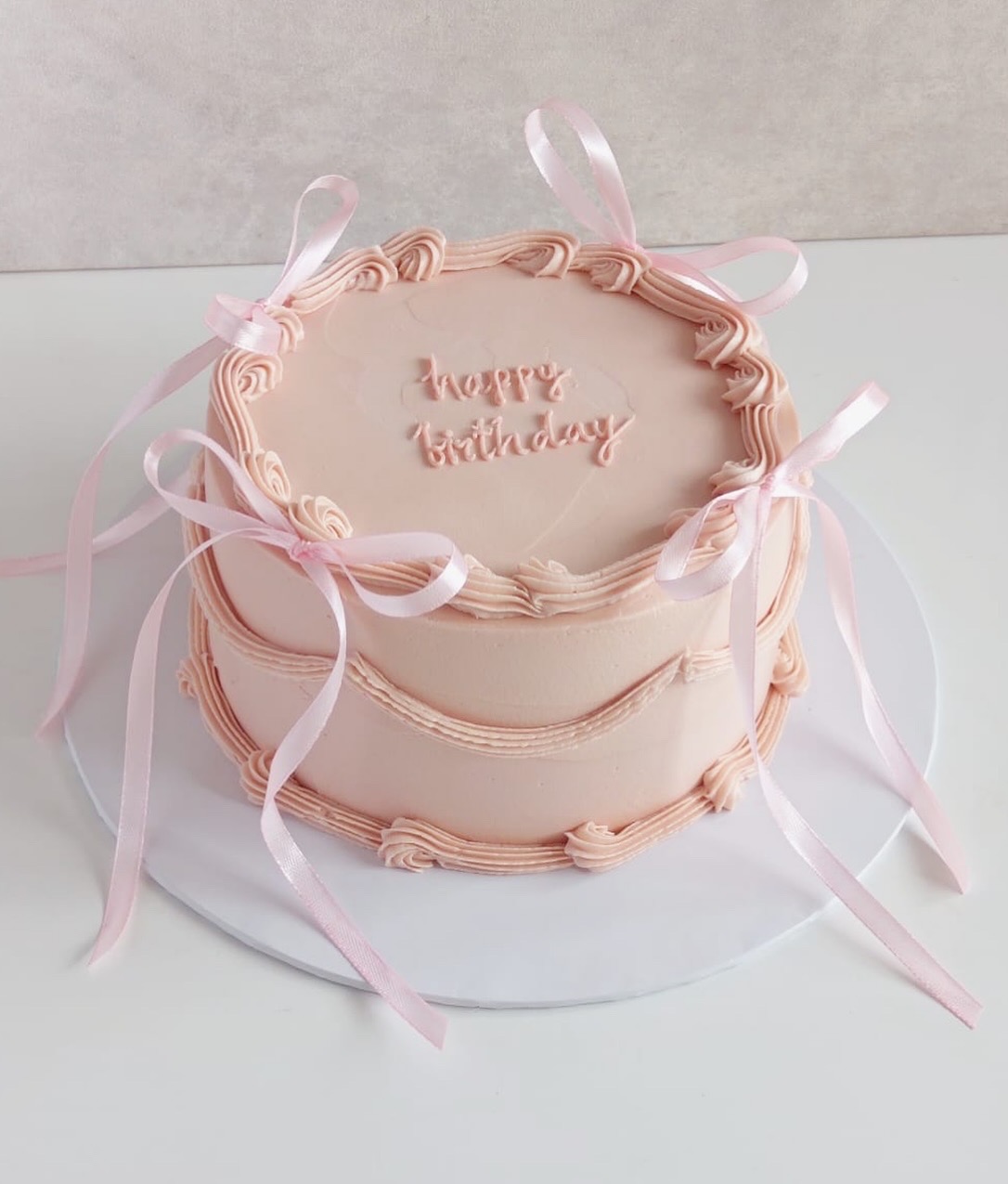 Light pink color cake with baby ribbon . 1kg